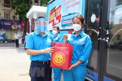 Công nhân Công ty Trách nhiệm hữu hạn Một thành viên Nước sạch Hà Đông nhận quà hỗ trợ từ lãnh đạo tổ chức Công đoàn Thủ đô. (Ảnh: TTXVN phát)