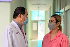 Bệnh nhân trò chuyện với bác sỹ phẫu thuật sau 15 ngày phẫu thuật. (Ảnh: Đinh Hằng/TTXVN)