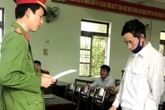 Cơ quan Công an thị xã Ba Đồn, tỉnh Quảng Bình, tống đạt quyết định khởi tố vụ án, khởi tố bị can và bắt tạm giam Trương Thanh Huỷnh (sinh năm 1962, trú tại xã Quảng Sơn, thị xã Ba Đồn, Quảng Bình), một trong hai đối tượng của vụ án. (Ảnh: TTXVN phát)