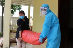 Đội ngũ tình nguyện viên chuyển thực phẩm từ các nhà tài trợ mang đến phát cho người dân tại xã Mão Điền. (Ảnh: Thanh Thương/TTXVN)