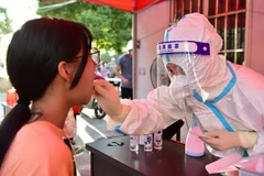 Nhân viên y tế lấy mẫu xét nghiệm COVID-19 cho người dân tại tỉnh Phúc Kiến, Trung Quốc. (Ảnh: THX/TTXVN)