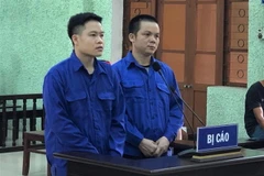 Hai đối tượng tại phiên tòa xét xử sơ thẩm. (Ảnh: Trí Tuệ/TTXVN phát)