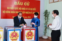 Chủ tịch nước Nguyễn Xuân Phúc cùng Phu nhân và Bí thư Thành ủy Thành phố Hồ Chí Minh Nguyễn Văn Nên bỏ phiếu bầu đại biểu Quốc hội khóa XV và Hội đồng nhân dân các cấp nhiệm kỳ 2021-2026. (Ảnh: Thống Nhất/TTXVN)