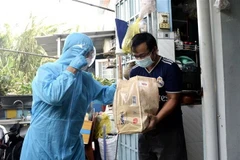 Đại diện Liên đoàn Lao động thành phố Thủ Đức trao tặng quà cho người lao động gặp khó khăn do dịch COVID-19. (Ảnh: Thanh Vũ/TTXVN)