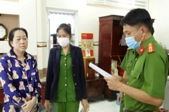 Cơ quan điều tra đọc lệnh khám xét nhà Nguyễn Thị Kim Hạnh đối tượng cầm đầu vụ vận chuyển trái phép 51kg vàng qua biên giới. (Ảnh: TTXVN phát)