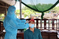 Test nhanh cho ngư dân trước khi lên bờ ở thị trấn Vàm Láng. (Ảnh: Hữu Chí/TTXVN)