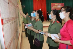 Cử tri của Bắc Kạn nghiên cứu tiểu sử của các ứng cử viên trước khi bỏ phiếu. (Ảnh: Hoàng Giang/TTXVN)