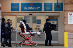 Nhân viên y tế chuyển bệnh nhân COVID-19 vào một bệnh viện ở New York, Mỹ. (Ảnh: AFP/TTXVN)