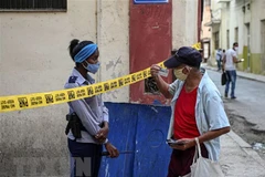 Cảnh sát gác tại một khu vực bị phong tỏa sau khi phát hiện ca mắc COVID-19 tại La Habana, Cuba. (Ảnh: AFP/TTXVN)
