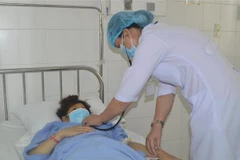 Các bác sỹ Bệnh viện Đa khoa Trung ương Cần Thơ thăm khám cho bệnh nhân Đ.T.T sau phẫu thuật. (Ảnh: TTXVN phát)