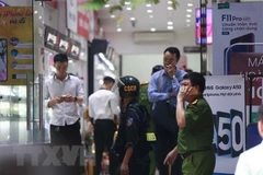Cảnh sát kiểm tra, khám xét tại cửa hàng điện thoại Nhật Cường mobile ở 33 Lý Quốc Sư, Hà Nội. (Ảnh: Doãn Tấn/TTXVN).