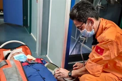 Lực lượng cứu nạn chăm sóc y tế cho nạn nhân trên tàu SAR 274. (Ảnh: TTXVN phát)