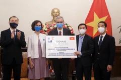 Thứ trưởng Ngoại giao Tô Anh Dũng và Thứ trưởng Bộ Y tế Trần Văn Thuấn tiếp nhận tượng trưng 672.000 liều vaccine AstraZeneca do Chính phủ và nhân dân Pháp ủng hộ. (Ảnh: Lâm Khánh/TTXVN)