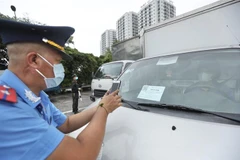 Lực lượng chức năng kiểm tra mã nhận diện QR Code của phương tiện. (Nguồn: TTXVN)