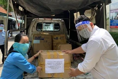 Liên đoàn Lao động quận Gò Vấp hỗ trợ khẩn cấp đồ dùng thiết yếu, nhu yếu phẩm cho công nhân tại phường 15, quận Gò Vấp. (Ảnh: TTXVN phát)