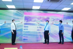 Ông Nguyễn Trọng Nghĩa, Bí thư Trung ương Đảng, Trưởng Ban Tuyên giáo Trung ương cùng các đại biểu thực hiện nghi thức khai trương giao diện mới và ra mắt ứng dụng trên thiết bị di động của Báo điện tử Đảng Cộng sản Việt Nam. (Ảnh: Phương Hoa/TTXVN)