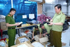 Lực lượng chức năng kiểm tra, niêm phong toàn bộ số hàng vi phạm. (Ảnh: Thùy Dung/TTXVN)