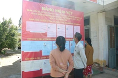 Cử tri xã đảo Hưng Phong (Giồng Trôm, Bến Tre) xem tiểu sử ứng cử viên biểu Quốc hội và đại biểu HĐND. (Ảnh: Công Trí/TTXVN)