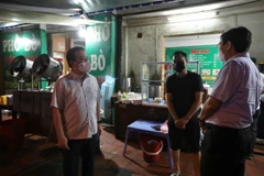 Đoàn kiểm tra, nhắc nhở quán phở trên phố Đền Lừ 2, phường Hoàng Văn Thụ, quận Hoàng Mai mở cửa sau 21 giờ. (Ảnh: Minh Quyết/TTXVN)
