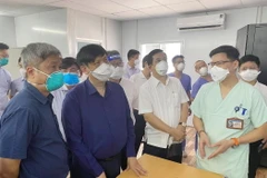 Bộ trưởng Bộ Y tế nghe báo cáo công tác thu dung, điều trị của Bệnh viện Hữu nghị Việt Đức tại Bệnh viện Dã chiến số 13. (Ảnh: TTXVN phát)