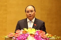 Phó Thủ tướng Nguyễn Xuân Phúc trình bày Báo cáo của Chính phủ tại phiên khai mạc. (Ảnh: Nhan Sáng/TTXVN)