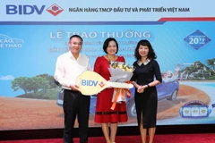 Khách hàng Định Thị Nhâm nhận giải đặc biệt từ chương trình. (Ảnh: C.N/Vietnam+)