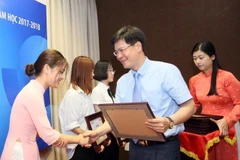Lãnh đạo LienVietPostBank trao học bổng cho các sinh viên. (Ảnh: CTV)