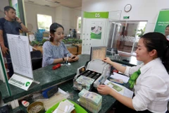 Giao dịch tại ngân hàng. (Ảnh: CTV/Vietnam+)