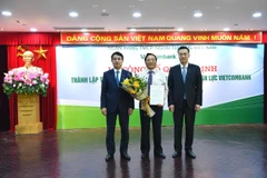 Lãnh đạo Vietcombank trao quyết định và tặng hoa cho ông Kiều Hữu Thiện, tân Giám đốc Trường Đào tạo Vietcombank. (Ảnh: CTV/Vietnam+)