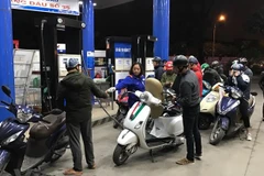 Nhân viên Petrolimex đang bán xăng cho khách hàng. (Ảnh: Đức Duy/Vietnam+)