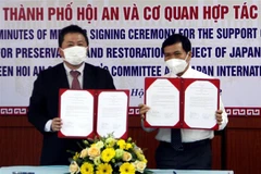 Ông Nguyễn Văn Sơn, Chủ tịch Ủy ban Nhân dân thành phố Hội An, trao đổi văn bản ký kết hỗ trợ với ông Shimizu Akira, Trưởng Đại diện Văn phòng JICA Việt Nam. (Ảnh: Trịnh Bang Nhiệm/TTXVN)