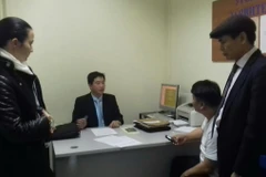 Đại diện Nga và Việt Nam làm thủ tục bàn giao đối tượng Nguyễn Xuân Đại về nước. (Ảnh: Dương Trí/Vietnam+)