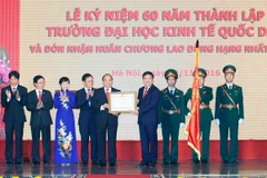 Thủ tướng Nguyễn Xuân Phúc trao tặng Huân chương Lao động hạng Nhất của Chủ tịch nước cho Trường Đại học Kinh tế Quốc dân. (Ảnh: Thống Nhất/TTXVN)