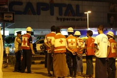 Lực lượng cứu hộ làm nhiệm vụ tại hiện trường vụ nổ trên phố Tharyar rạng sáng 21/11. (Nguồn: THX/TTXVN)