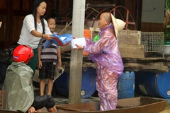 Thầy Thích Tâm Phát đại diện cho các phật tử ở Thành phố Hồ Chí Minh trao quà hỗ trợ người dân bị ngập ở xóm 4, xã Hà Linh (Hương Khê). (Ảnh: Việt Hoàng/Vietnam+)