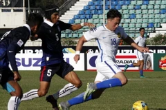 Cầu thủ Darren Yee Deng Lok (phải), đội Malaysia đi bóng trước sự truy cản của cầu thủ Soeuy Visal (giữa) đội Campuchia. (Nguồn: AP/TTXVN)