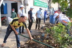 Công nhân, người lao động tham gia dọn dẹp vệ sinh môi trường tại khu trọ. (Ảnh: Xuân Dự/TTXVN)