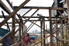 Các hộ dân bị thiệt hại trong trận hỏa hoạn đang tích cực sửa chữa nhà cửa. (Ảnh: Chanh Đa/TTXVN)