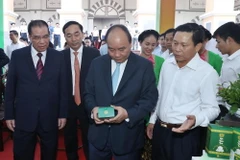 Thủ tướng Nguyễn Xuân Phúc và các đại biểu tham quan gian hàng trưng bày các sản phẩm của tỉnh Thái Nguyên tại hội nghị. (Ảnh: Thống Nhất/TTXVN)