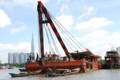 Lực lượng chức năng đang khẩn trương tìm kiếm nạn nhân mất tích và trục vớt sà lan bị chìm. (Ảnh: Hoàng Anh Tuấn/TTXVN)