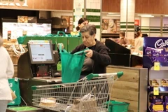 Khách mua hàng tại siêu thị Woolworths sử dụng túi cá nhân thay thế túi nilon sử dụng một lần phát miễn phí. (Ảnh: Diệu Linh/TTXVN)