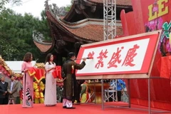 Nhà thư pháp Phạm Hùng trình diễn khai bút Hán văn. (Ảnh: Mạnh Minh/TTXVN)