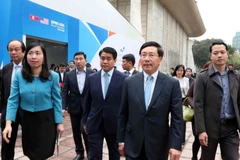 ​Bà Lê Thị Thu Hằng (áo xanh) cùng Phó Thủ tướng, Bộ trưởng Bộ Ngoại giao Phạm Bình Minh và các đại biểu dự Lễ khai trương Trung tâm Báo chí quốc tế phục vụ Hội nghị Thượng đỉnh Mỹ-Triều Tiên lần thứ hai. (Ảnh: Văn Điệp/TTXVN)