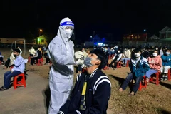 Lực lượng chức năng huyện biên giới Kỳ Sơn (Nghệ An) xuyên đêm xét nghiệm cho người dân. (Ảnh: Văn Tý/TTXVN)