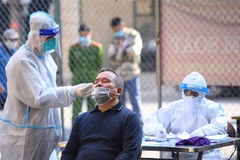 Lực lượng chức năng phường Nguyễn Du, Hà Nội tổ chức lấy mẫu xét nghiệm sàng lọc SARS-CoV-2 cho người dân trong khu vực bị phong tỏa. (Ảnh: Hoàng Hiếu/TTXVN)