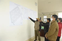 Các hộ dân xem vị trí các ô đất trước khi bốc thăm nhận vị trí đất dịch vụ. (Ảnh: Mạnh Khánh/TTXVN)