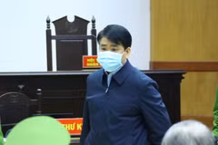 Cảnh sát dẫn giải cựu Chủ tịch UBND thành phố Hà Nội Nguyễn Đức Chung vào phòng xét xử. (Ảnh: TTXVN)