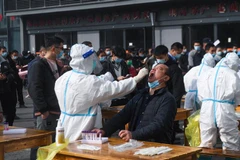 Nhân viên y tế lấy mẫu xét nghiệm COVID-19 tại khu chợ ở Hàng Châu, tỉnh Chiết Giang, Trung Quốc ngày 10/12/2021. (Ảnh: THX/TTXVN)