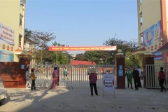 Phụ huynh Trường THCS Kim Tân, thành phố Lào Cai ở ngoài cổng trường đợi con em mình lấy mẫu xét nghiệm COVID-19. (Ảnh: TTXVN/phát)