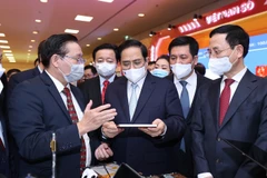 Thủ tướng Phạm Minh Chính tham quan gian trưng bày sản phẩm công nghệ số của các doanh nghiệp tham dự Diễn đàn. (Ảnh: Dương Giang/TTXVN)